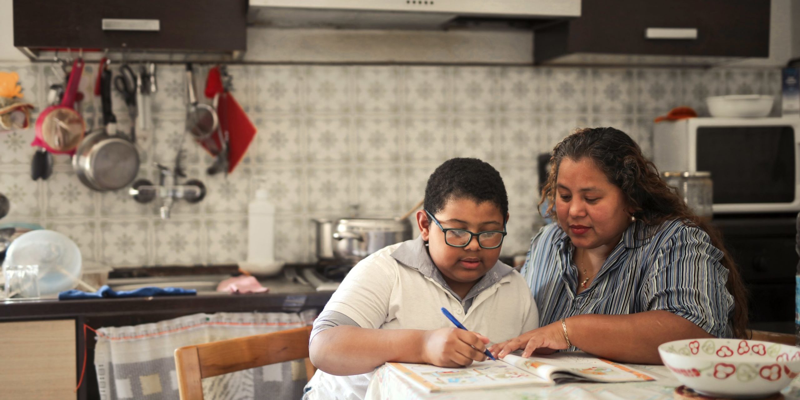 Mother Helps Her Son With Schoolwork