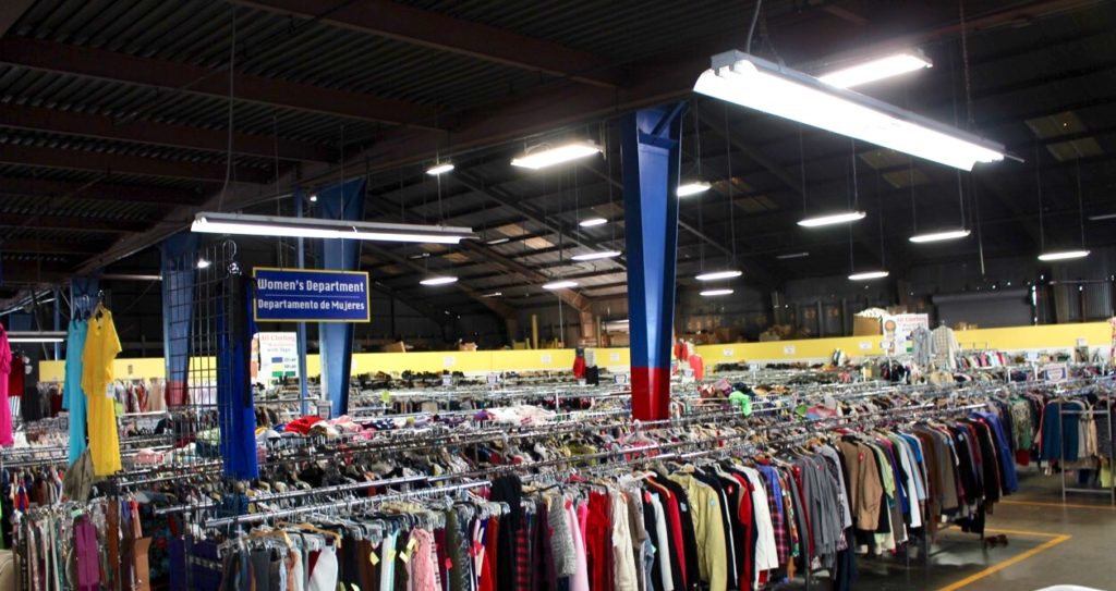 A warehouse filled with aisles of clothing. St. Vincent de Paul Thrift Store in Los Angeles. 